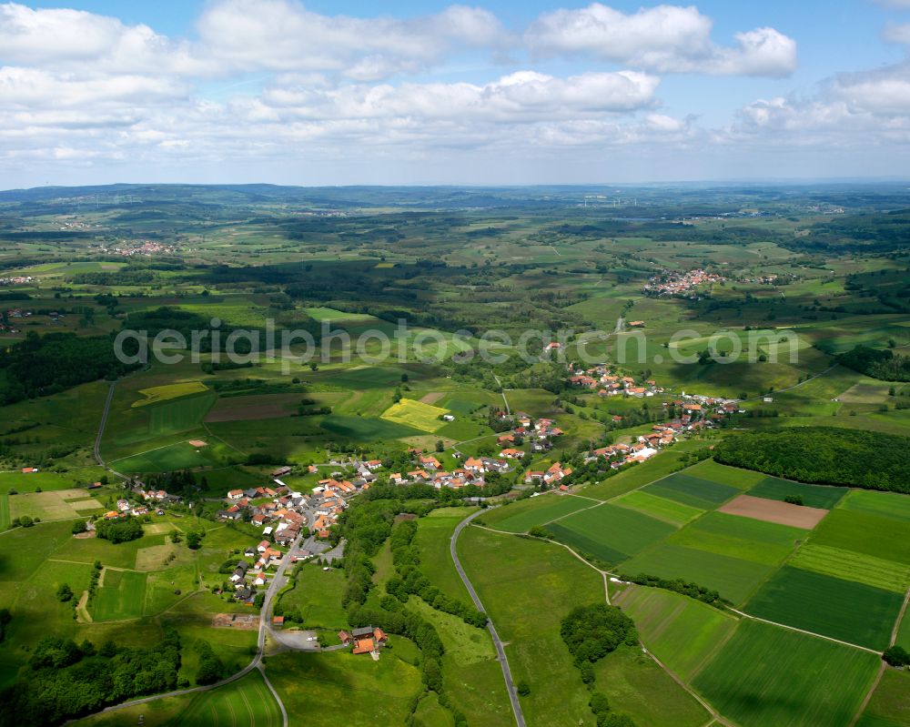 Radmühl from above - Agricultural land and field boundaries surround the settlement area of the village in Radmühl in the state Hesse, Germany