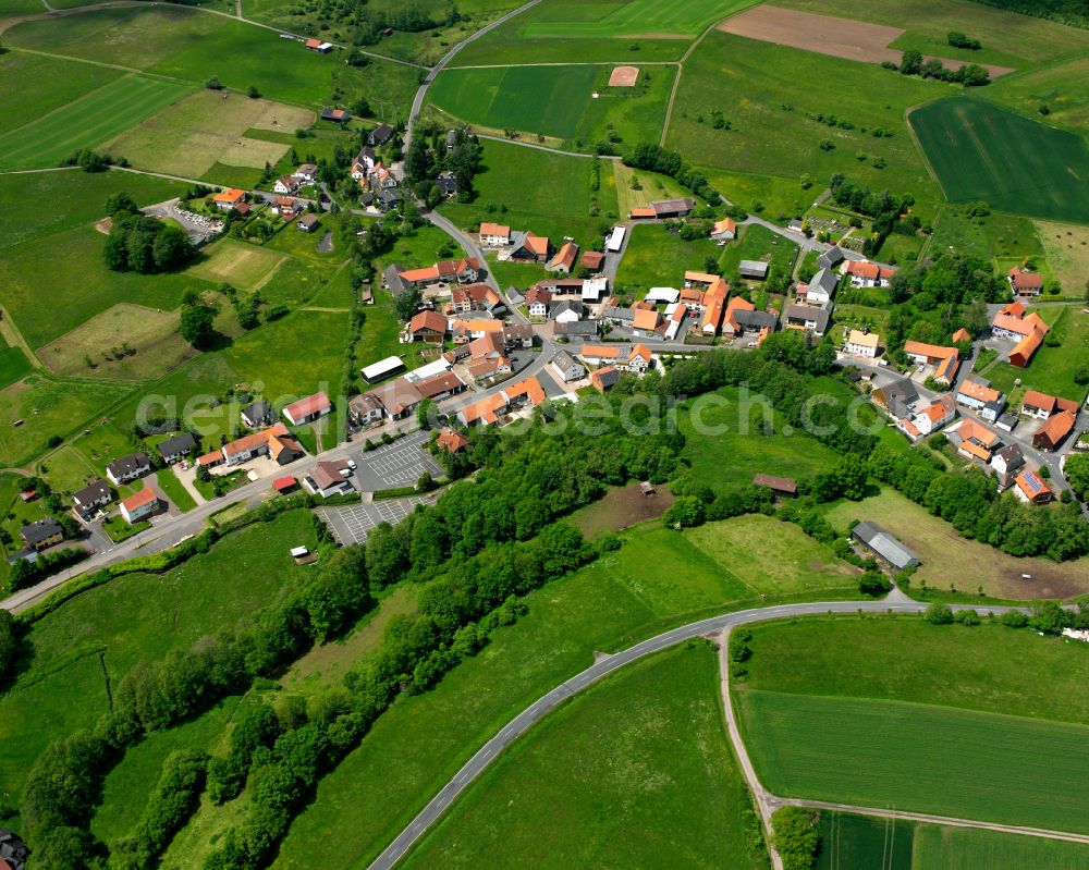 Aerial photograph Radmühl - Agricultural land and field boundaries surround the settlement area of the village in Radmühl in the state Hesse, Germany