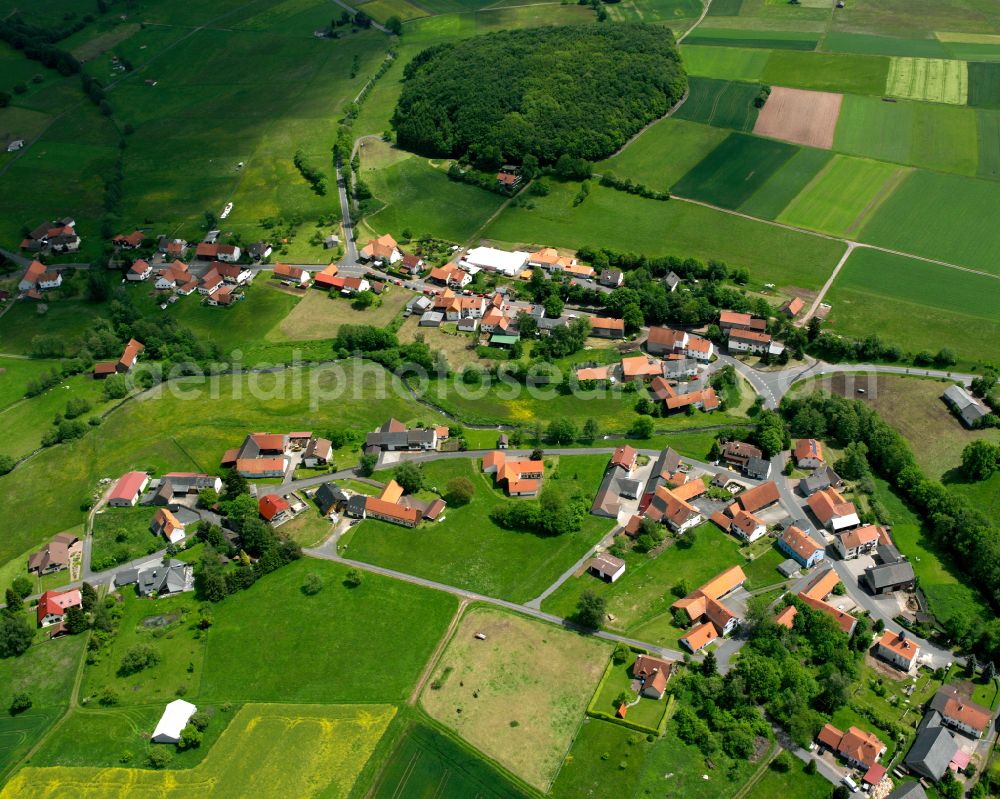 Aerial photograph Radmühl - Agricultural land and field boundaries surround the settlement area of the village in Radmühl in the state Hesse, Germany