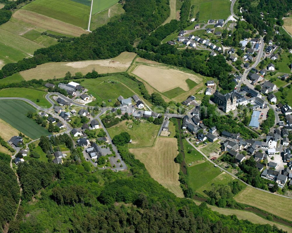 Ravengiersburg from the bird's eye view: Agricultural land and field boundaries surround the settlement area of the village in Ravengiersburg in the state Rhineland-Palatinate, Germany