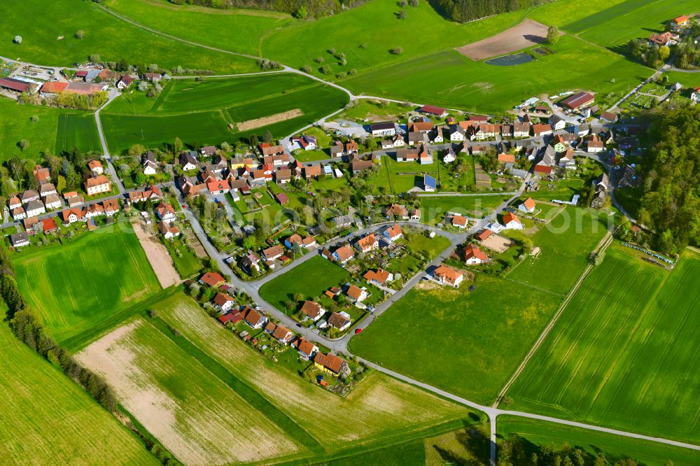 Rehweiler from above - Agricultural land and field boundaries surround the settlement area of the village in Rehweiler in the state Bavaria, Germany