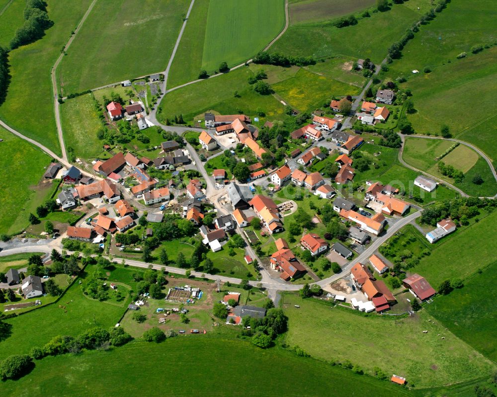 Reinhards from above - Agricultural land and field boundaries surround the settlement area of the village in Reinhards in the state Hesse, Germany