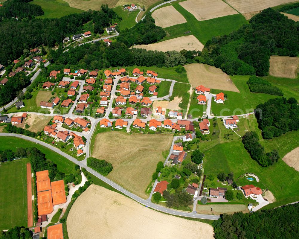 Reischach from above - Agricultural land and field boundaries surround the settlement area of the village in Reischach in the state Bavaria, Germany