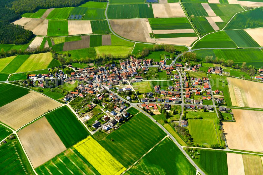 Reupelsdorf from above - Agricultural land and field boundaries surround the settlement area of the village in Reupelsdorf in the state Bavaria, Germany