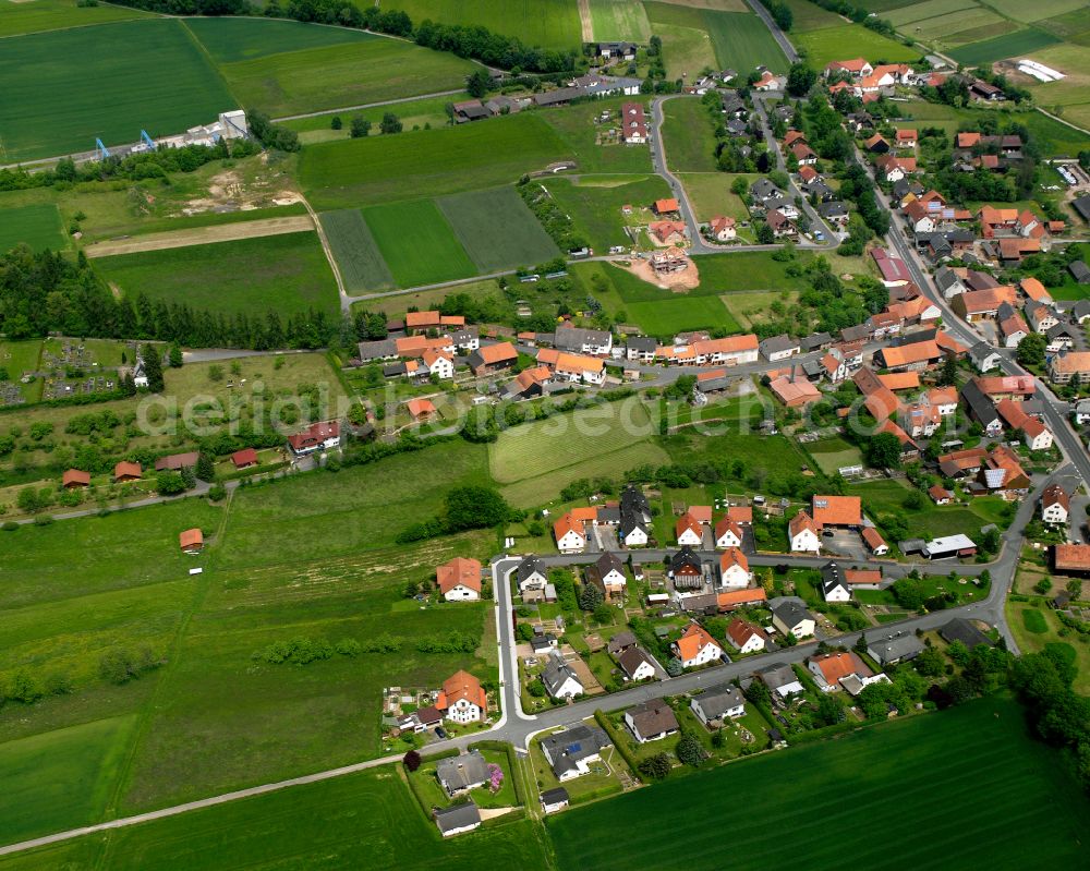 Rimbach from above - Agricultural land and field boundaries surround the settlement area of the village in Rimbach in the state Hesse, Germany