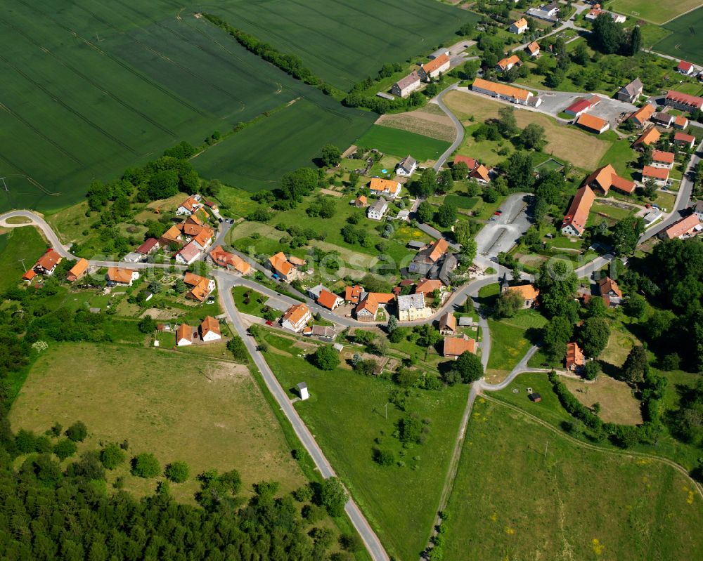 Rimbach from the bird's eye view: Agricultural land and field boundaries surround the settlement area of the village in Rimbach in the state Thuringia, Germany