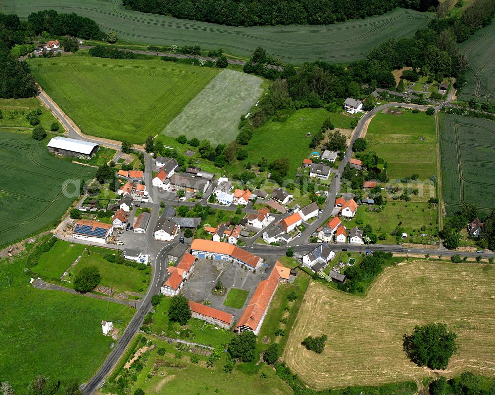 Rülfenrod from above - Agricultural land and field boundaries surround the settlement area of the village in Rülfenrod in the state Hesse, Germany