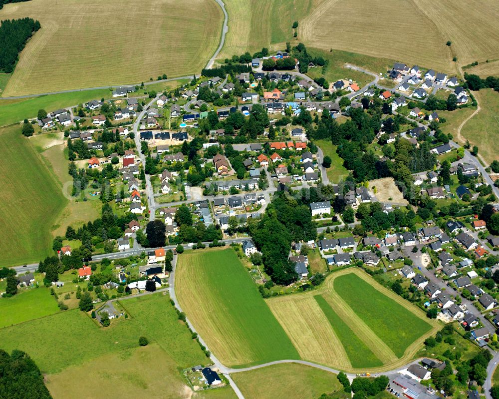 Rönsahl from the bird's eye view: Agricultural land and field boundaries surround the settlement area of the village in Rönsahl in the state North Rhine-Westphalia, Germany