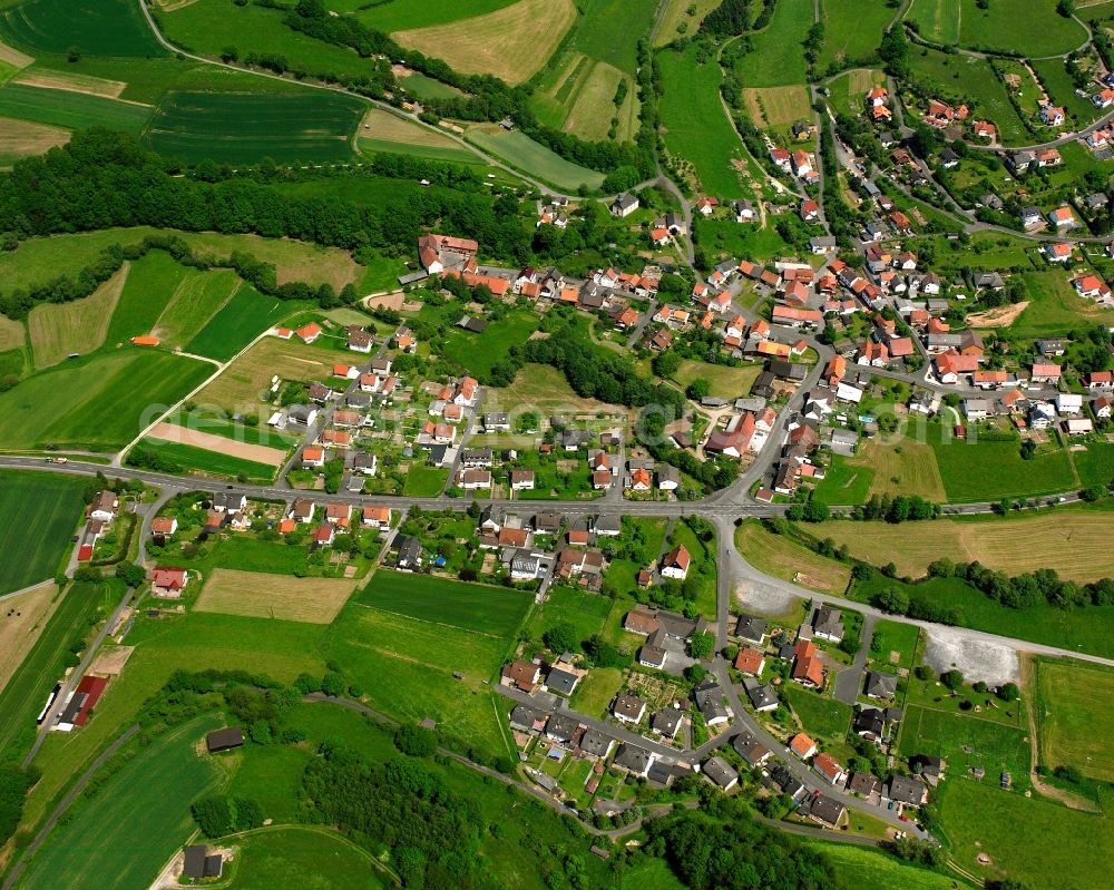 Rohrbach from above - Agricultural land and field boundaries surround the settlement area of the village in Rohrbach in the state Hesse, Germany