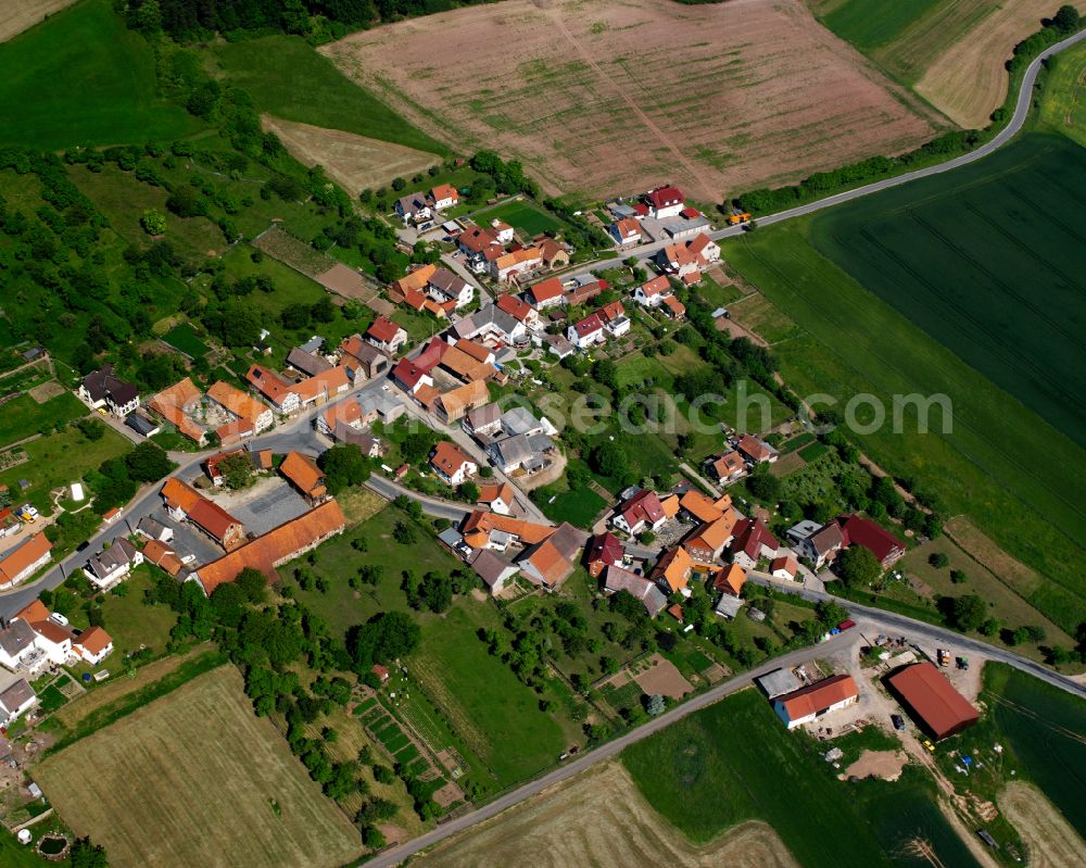 Rohrberg from the bird's eye view: Agricultural land and field boundaries surround the settlement area of the village in Rohrberg in the state Thuringia, Germany