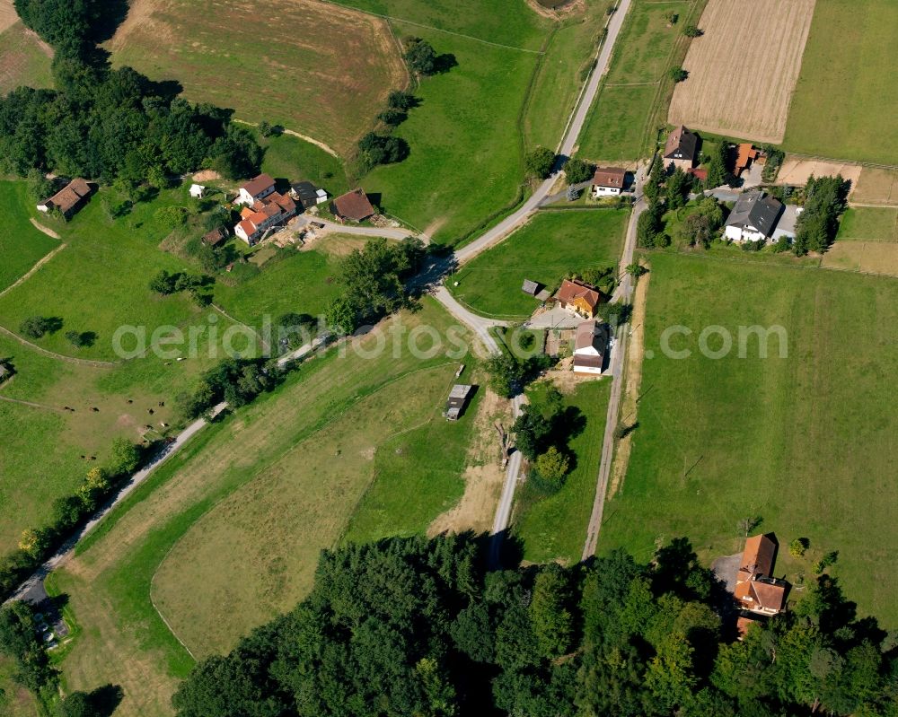 Roßbach from above - Agricultural land and field boundaries surround the settlement area of the village in Roßbach in the state Hesse, Germany