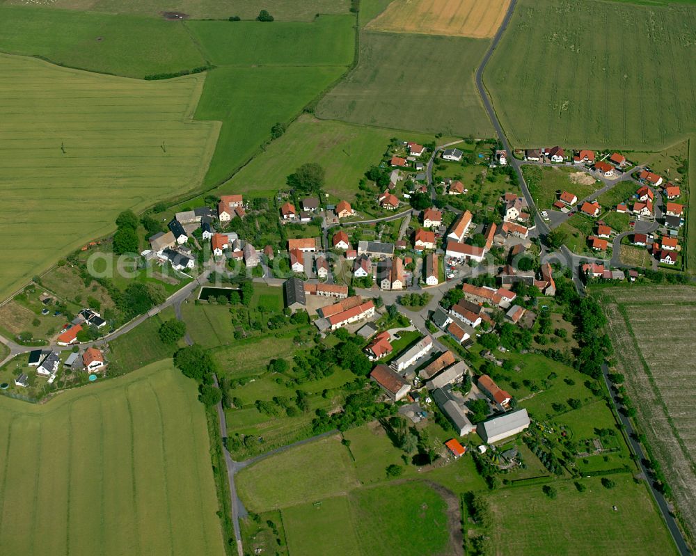 Rostig from the bird's eye view: Agricultural land and field boundaries surround the settlement area of the village in Rostig in the state Saxony, Germany