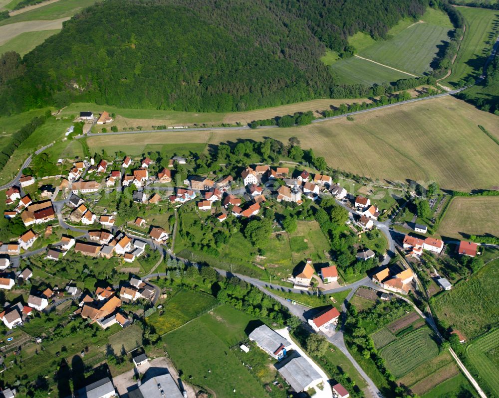 Aerial image Rüstungen - Agricultural land and field boundaries surround the settlement area of the village in Rüstungen in the state Thuringia, Germany