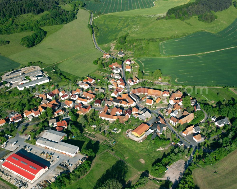 Rüstungen from the bird's eye view: Agricultural land and field boundaries surround the settlement area of the village in Rüstungen in the state Thuringia, Germany