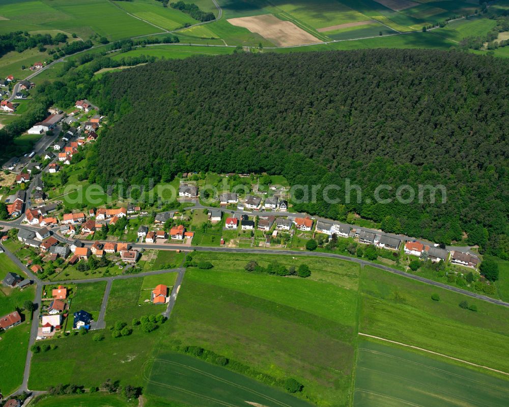 Ruhlkirchen from above - Agricultural land and field boundaries surround the settlement area of the village in Ruhlkirchen in the state Hesse, Germany