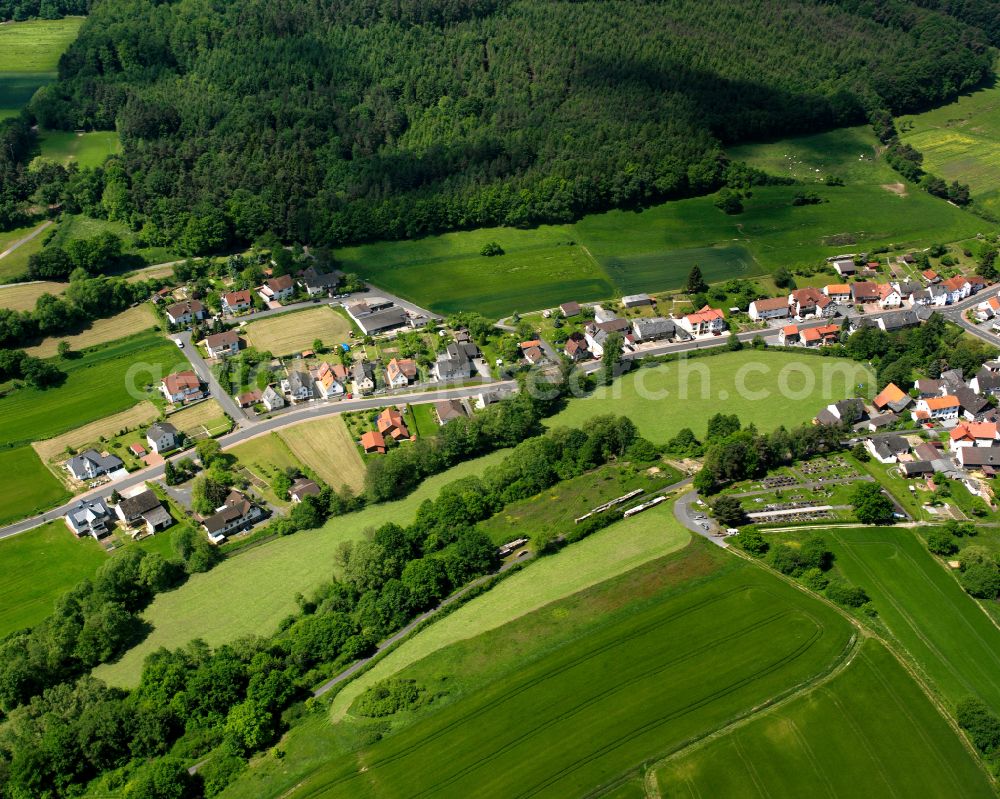 Ruhlkirchen from the bird's eye view: Agricultural land and field boundaries surround the settlement area of the village in Ruhlkirchen in the state Hesse, Germany