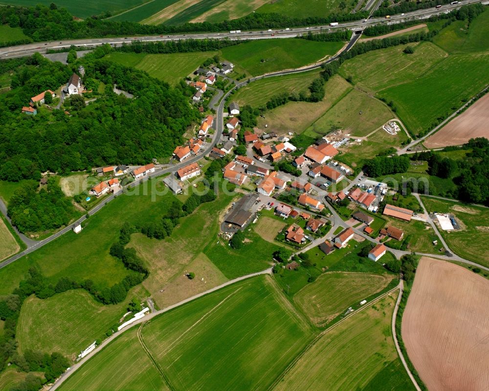 Saasen from above - Agricultural land and field boundaries surround the settlement area of the village in Saasen in the state Hesse, Germany