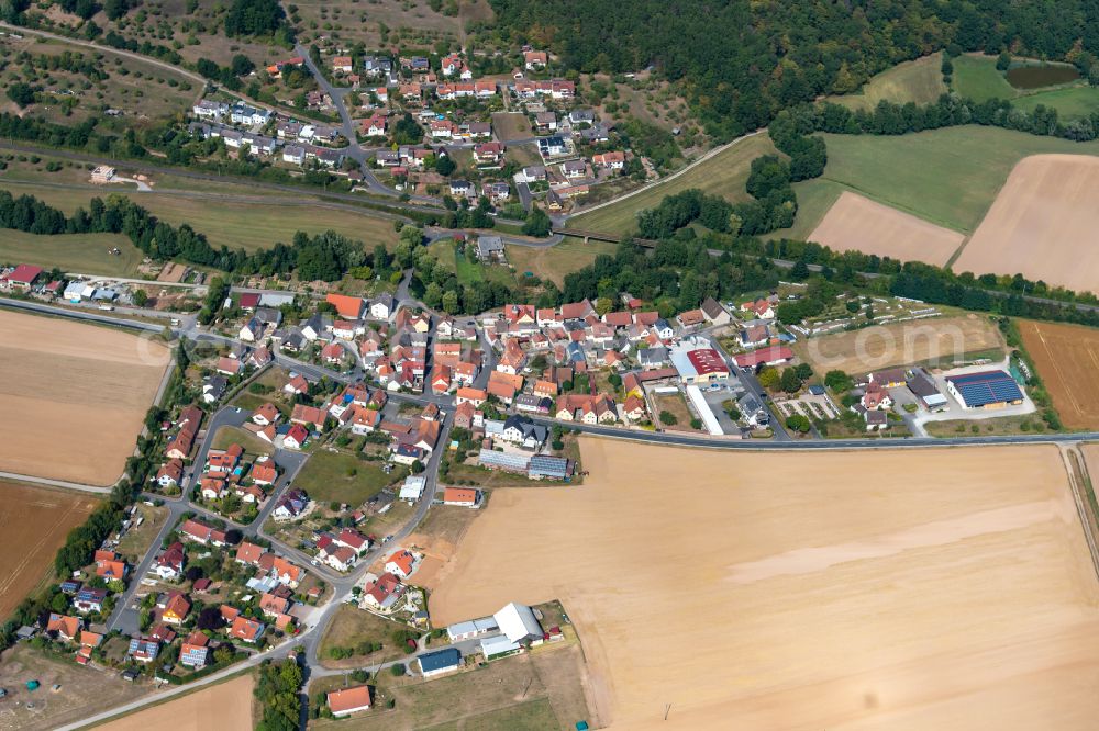 Sachsenheim from the bird's eye view: Agricultural land and field boundaries surround the settlement area of the village in Sachsenheim in the state Bavaria, Germany