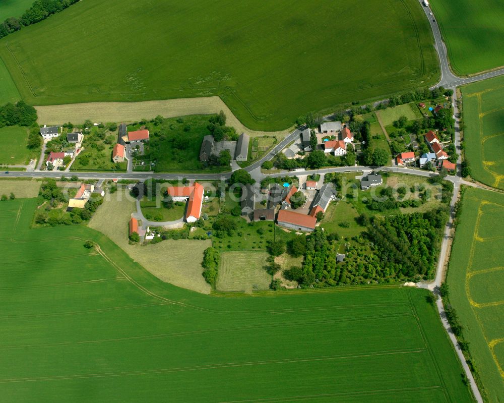 Sachsenroda from above - Agricultural land and field boundaries surround the settlement area of the village in Sachsenroda in the state Thuringia, Germany