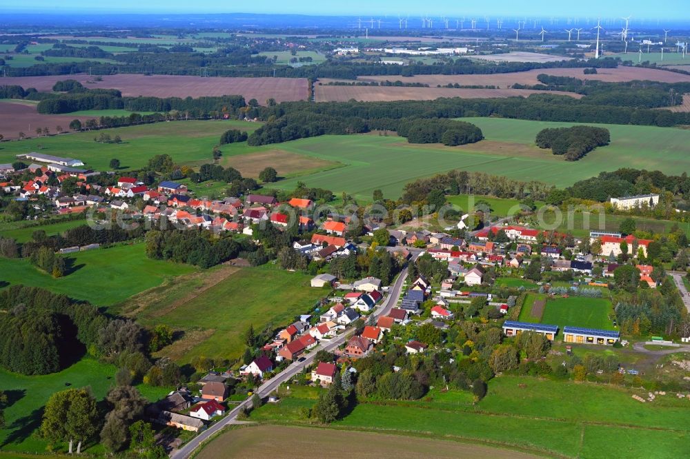 Sadenbeck from the bird's eye view: Agricultural land and field boundaries surround the settlement area of the village in Sadenbeck in the state Brandenburg, Germany