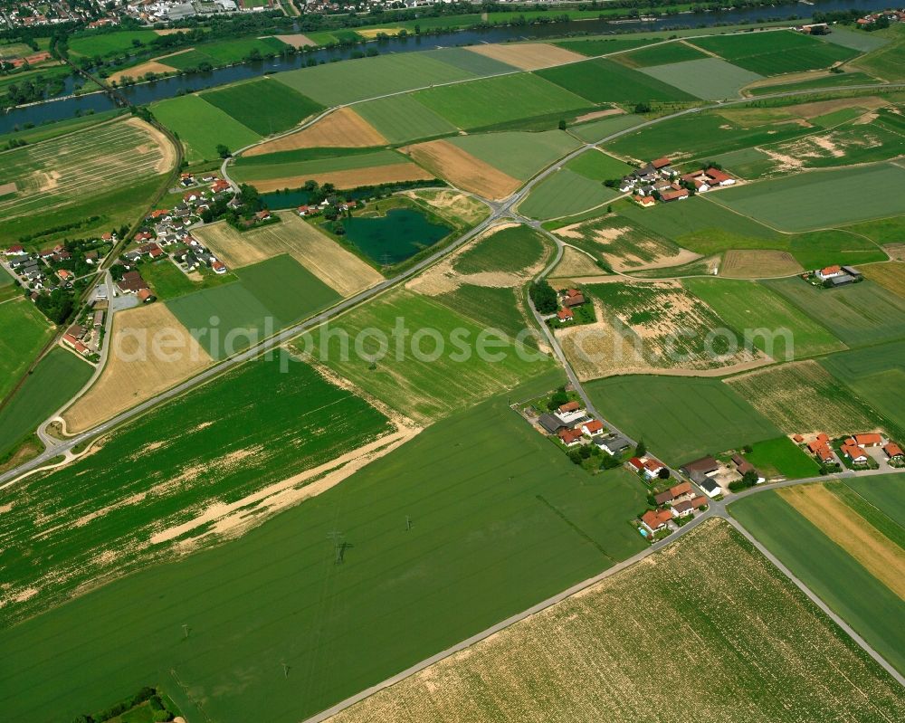 Sand from above - Agricultural land and field boundaries surround the settlement area of the village in Sand in the state Bavaria, Germany