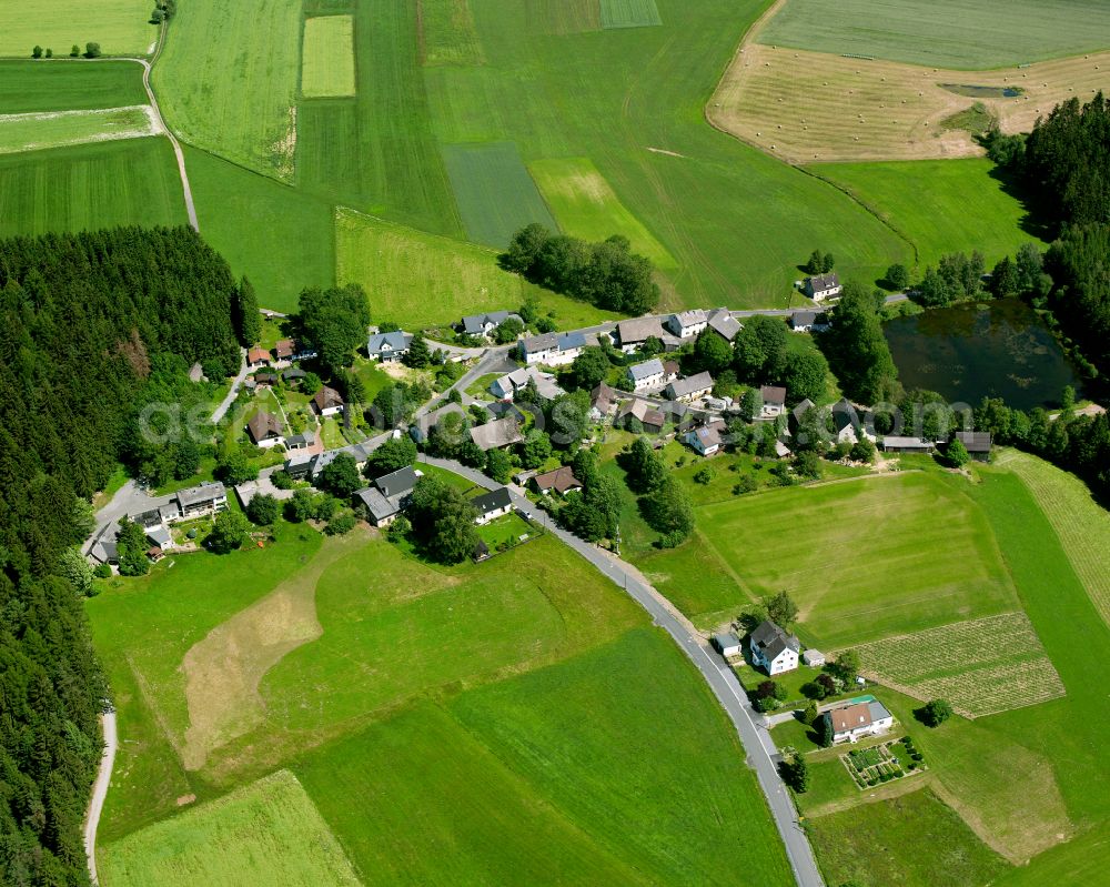 Sauerhof from the bird's eye view: Agricultural land and field boundaries surround the settlement area of the village in Sauerhof in the state Bavaria, Germany