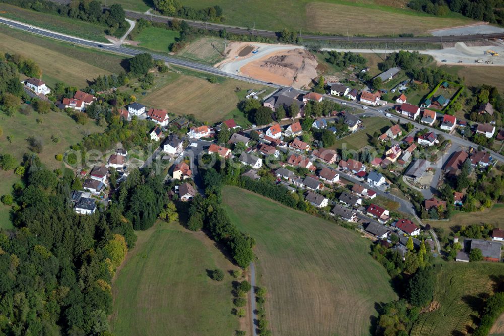 Schaippach from above - Agricultural land and field boundaries surround the settlement area of the village in Schaippach in the state Bavaria, Germany