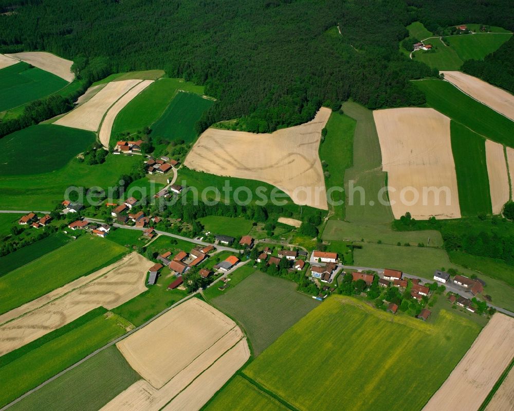 Schatzbach from above - Agricultural land and field boundaries surround the settlement area of the village in Schatzbach in the state Bavaria, Germany