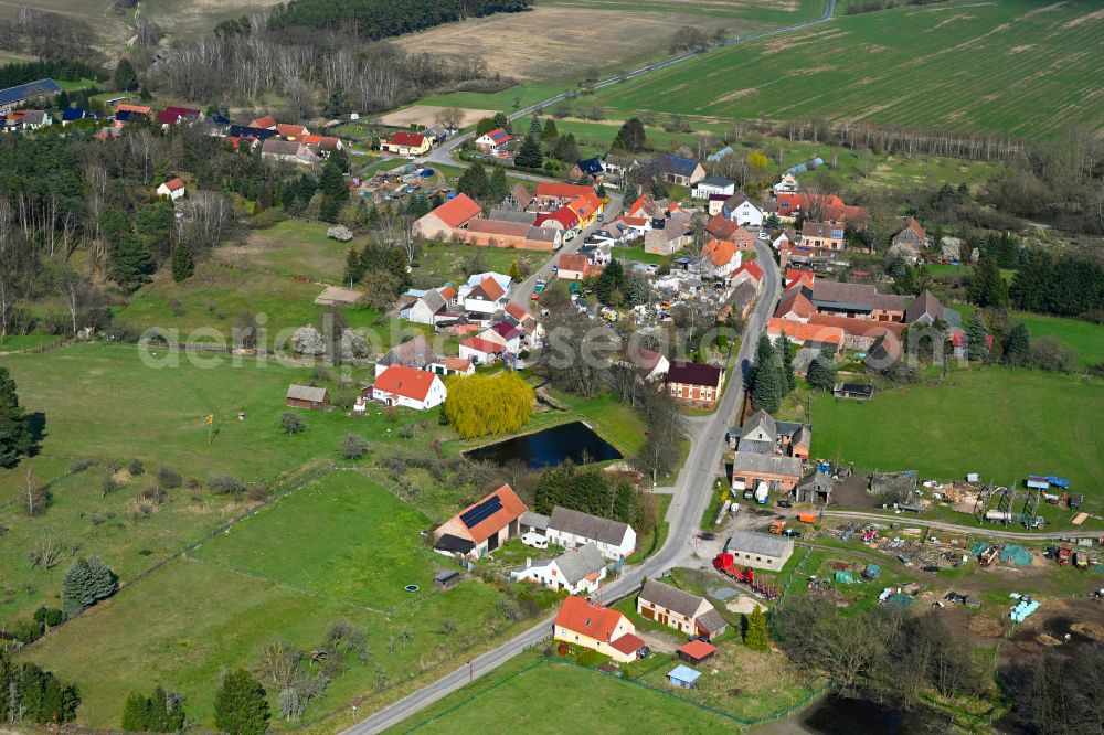 Schlamau from above - Agricultural land and field boundaries surround the settlement area of the village in Schlamau in the state Brandenburg, Germany