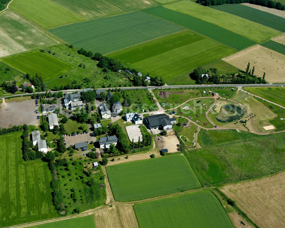 Auf dem Schmiedel from above - Agricultural land and field boundaries surround the settlement area of the village in Auf dem Schmiedel in the state Rhineland-Palatinate, Germany