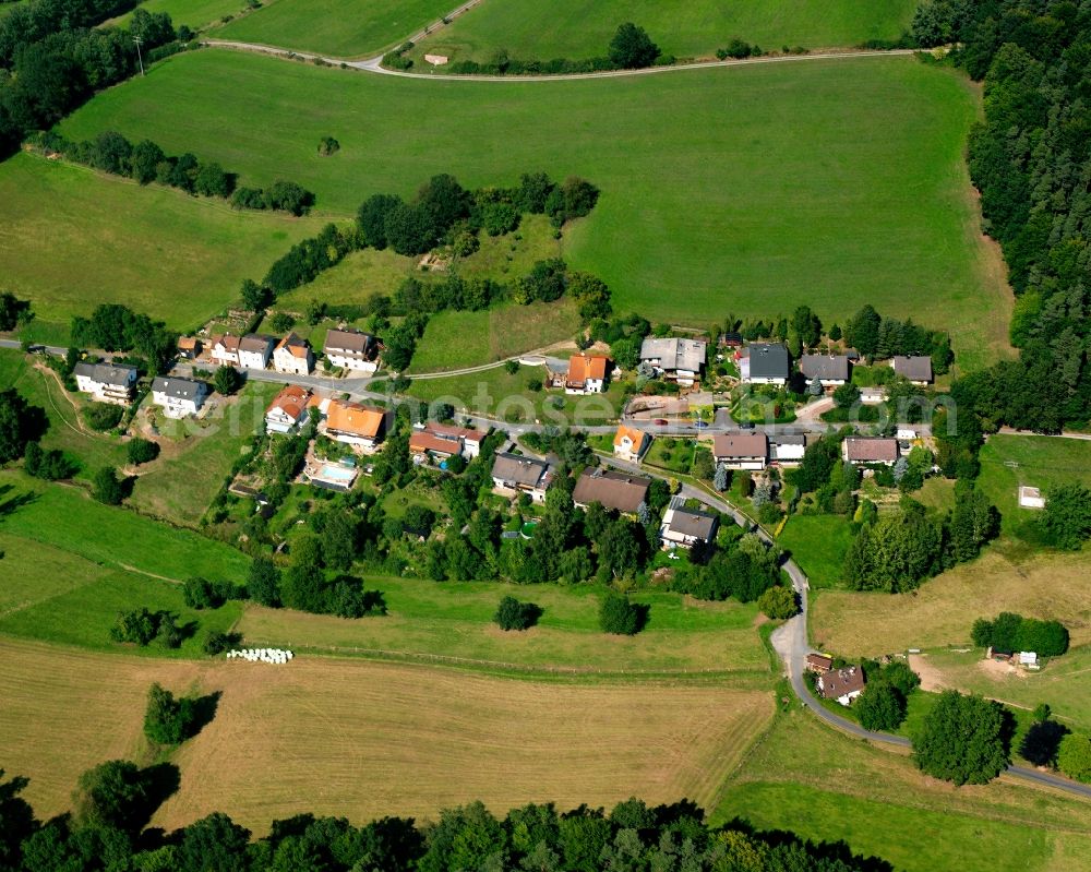 Schönnen from the bird's eye view: Agricultural land and field boundaries surround the settlement area of the village in Schönnen in the state Hesse, Germany