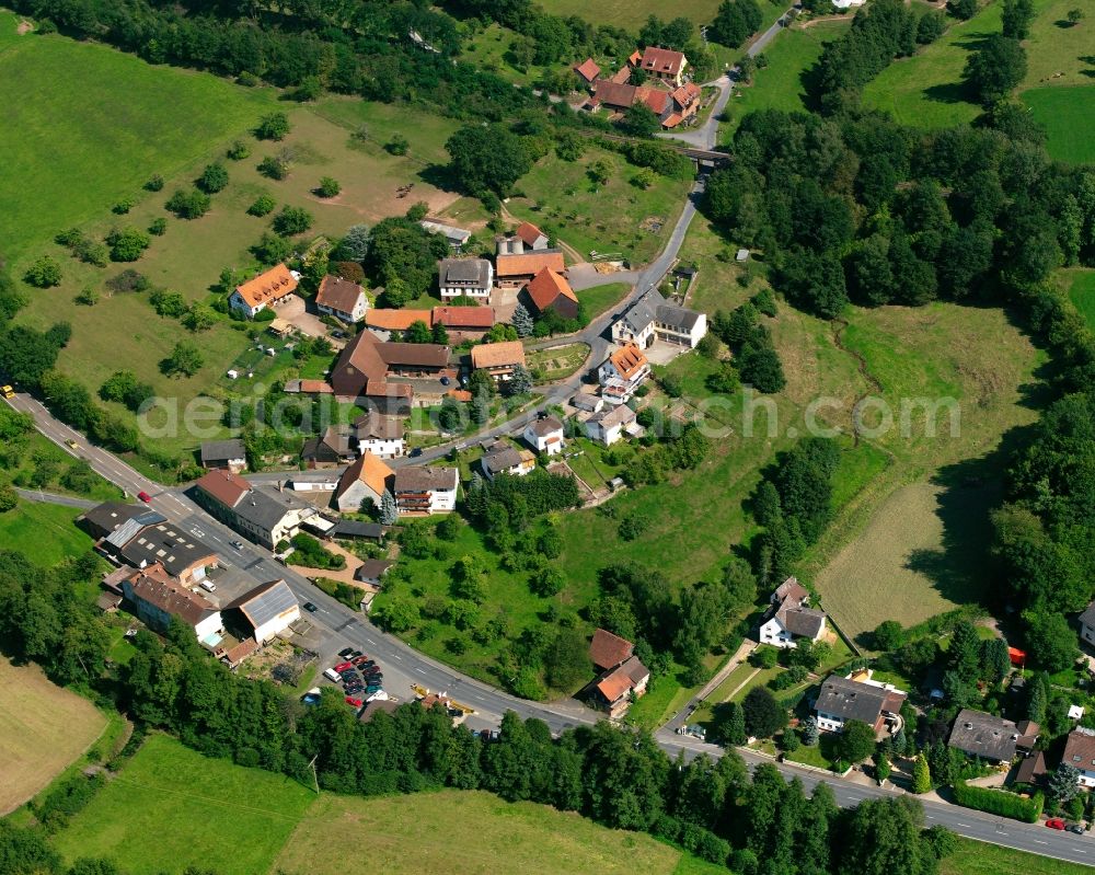 Aerial image Schönnen - Agricultural land and field boundaries surround the settlement area of the village in Schönnen in the state Hesse, Germany