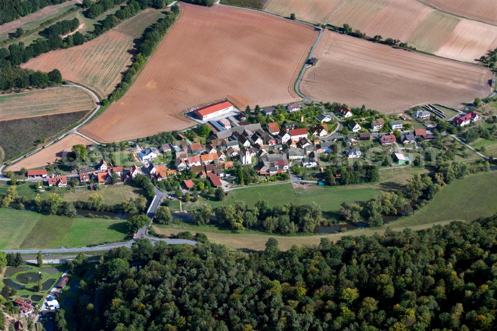 Schonderfeld from above - Agricultural land and field boundaries surround the settlement area of the village in Schonderfeld in the state Bavaria, Germany