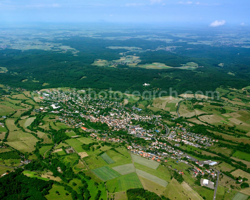 Schotten from the bird's eye view: Agricultural land and field boundaries surround the settlement area of the village in Schotten in the state Hesse, Germany