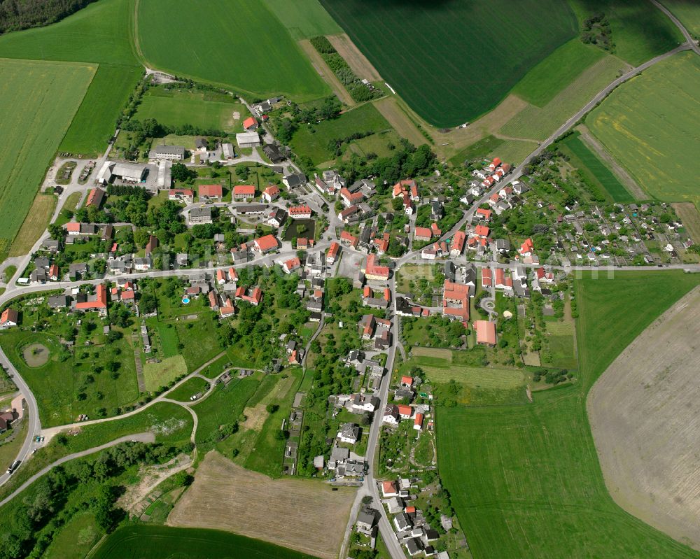 Schüptitz from the bird's eye view: Agricultural land and field boundaries surround the settlement area of the village in Schüptitz in the state Thuringia, Germany