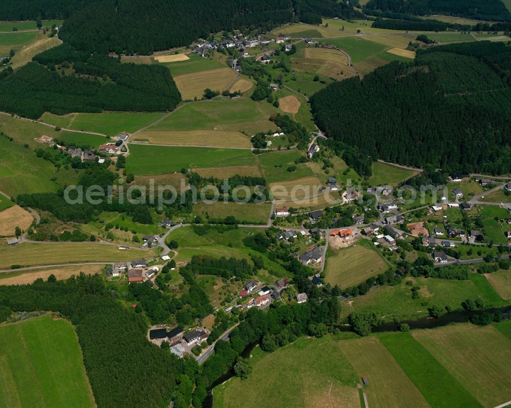 Schwarzenau from the bird's eye view: Agricultural land and field boundaries surround the settlement area of the village in Schwarzenau in the state North Rhine-Westphalia, Germany