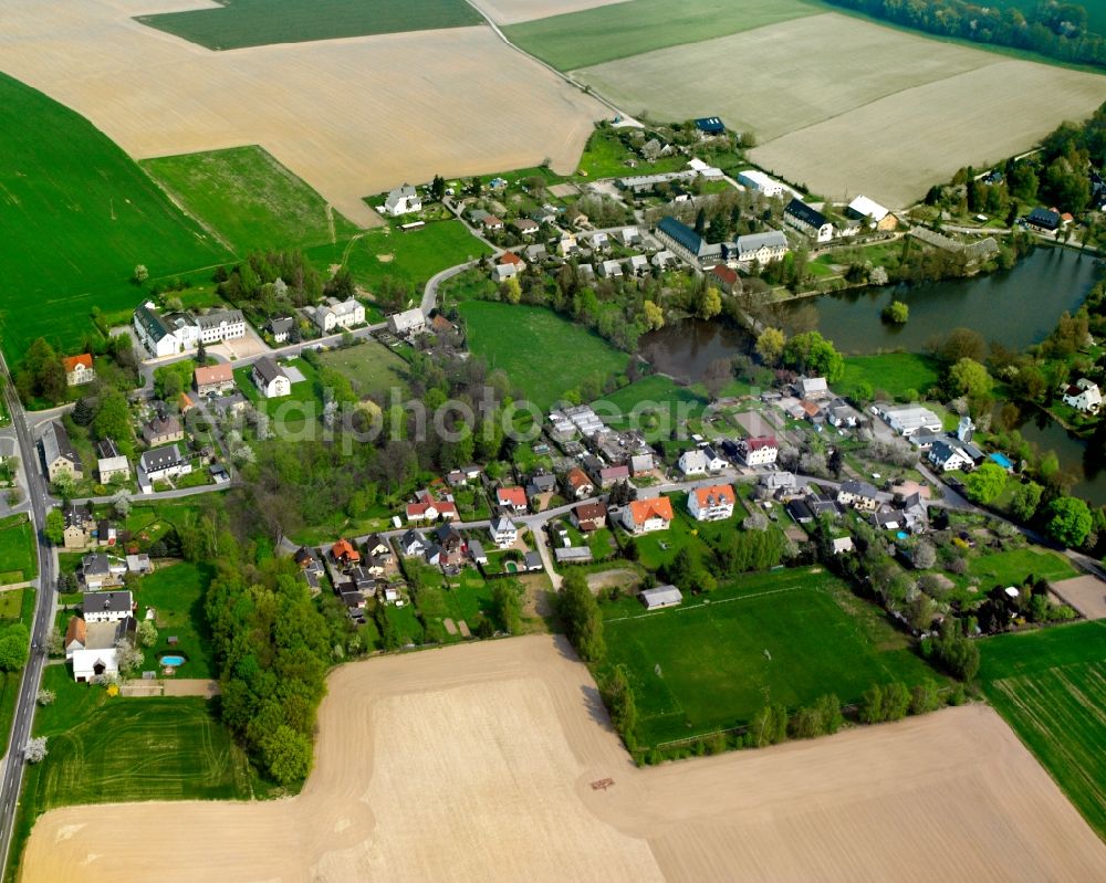 Schweikershain from the bird's eye view: Agricultural land and field boundaries surround the settlement area of the village in Schweikershain in the state Saxony, Germany