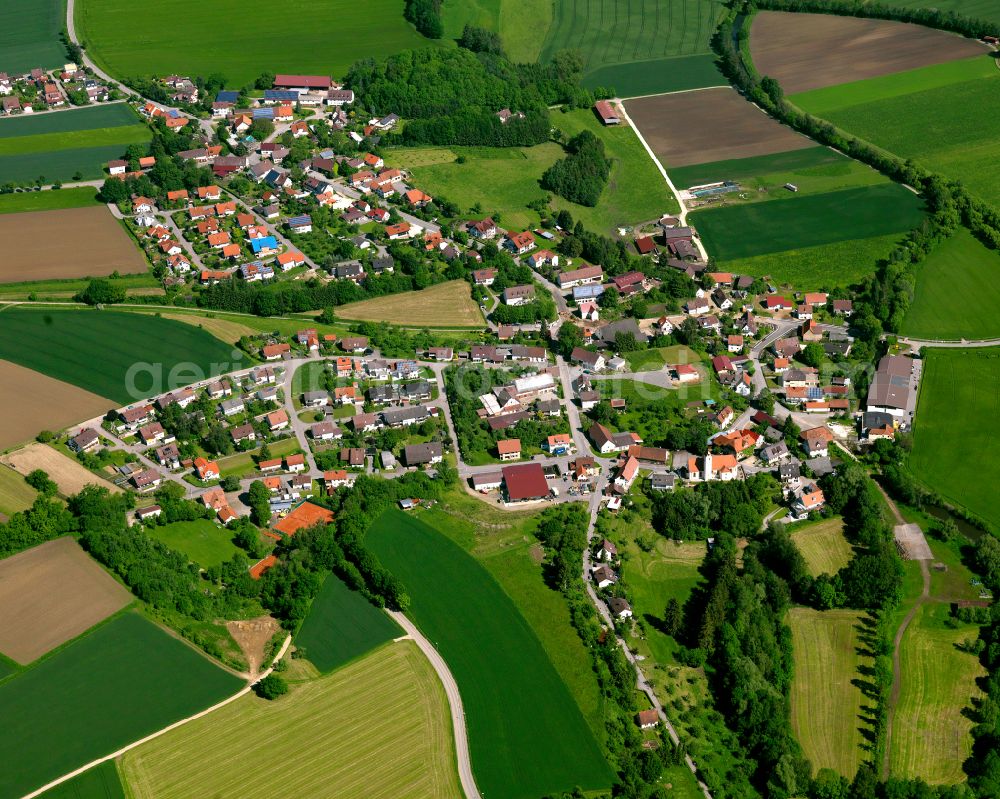 Schwendi from above - Agricultural land and field boundaries surround the settlement area of the village in Schwendi in the state Baden-Wuerttemberg, Germany