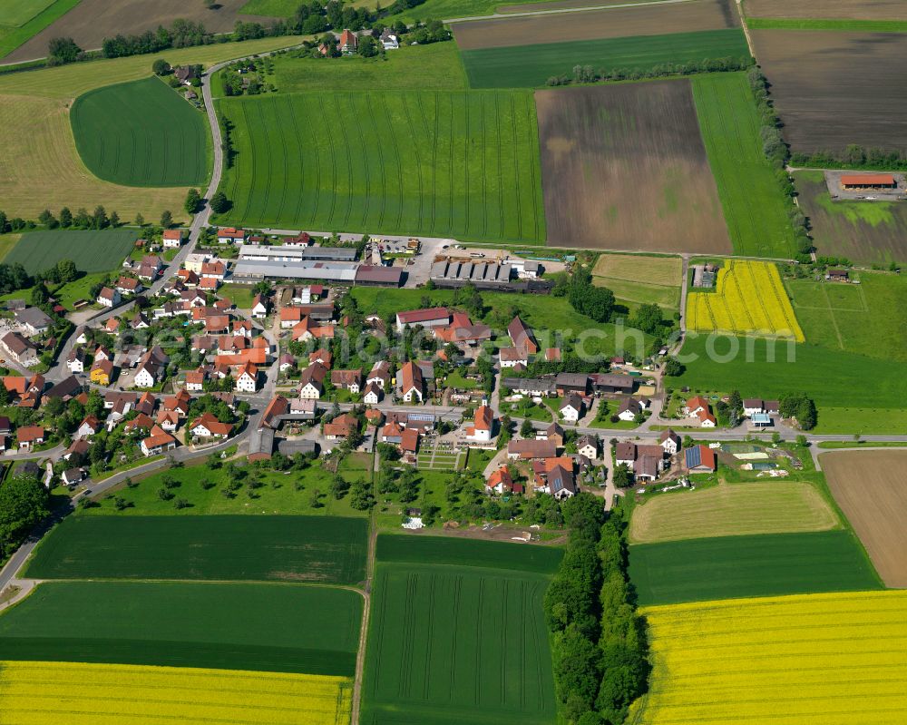 Schwendi from above - Agricultural land and field boundaries surround the settlement area of the village in Schwendi in the state Baden-Wuerttemberg, Germany