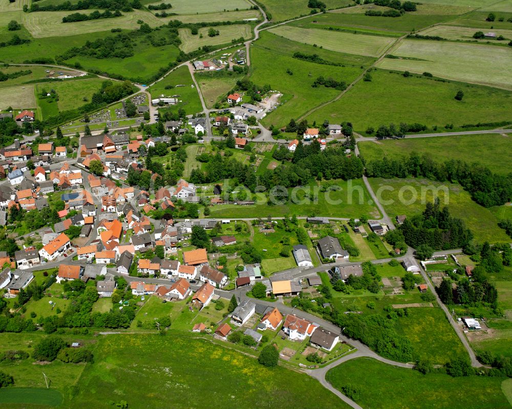 Sellnrod from the bird's eye view: Agricultural land and field boundaries surround the settlement area of the village in Sellnrod in the state Hesse, Germany