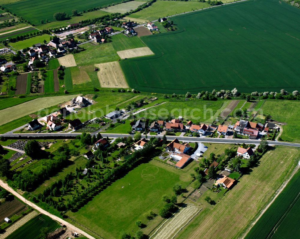 Silberhausen from above - Agricultural land and field boundaries surround the settlement area of the village in Silberhausen in the state Thuringia, Germany