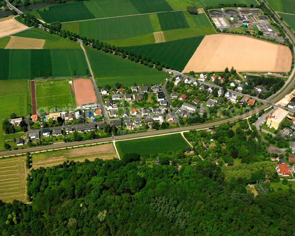 Aerial photograph Staffel - Agricultural land and field boundaries surround the settlement area of the village in Staffel in the state Hesse, Germany