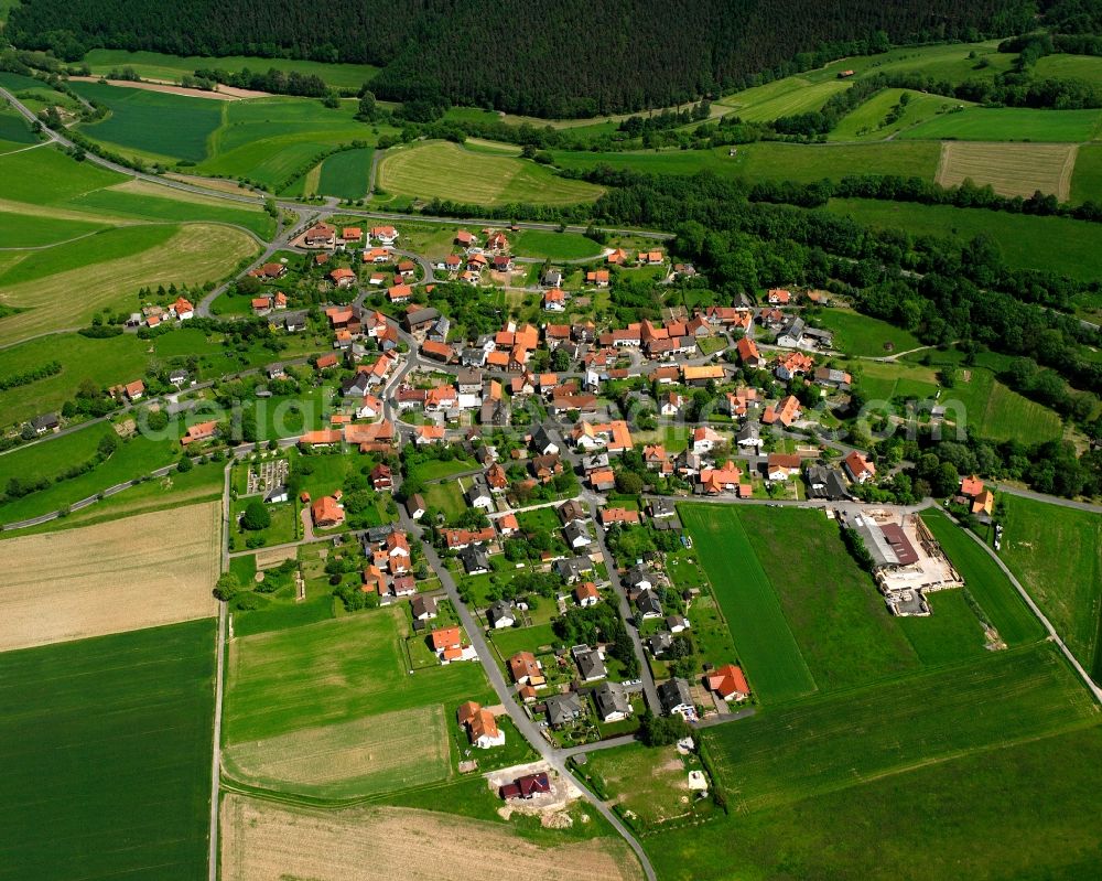 Aerial photograph Sterkelshausen - Agricultural land and field boundaries surround the settlement area of the village in Sterkelshausen in the state Hesse, Germany