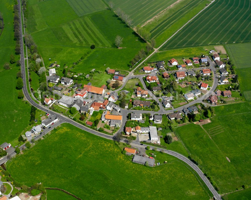 Stockhausen from above - Agricultural land and field boundaries surround the settlement area of the village in Stockhausen in the state Hesse, Germany