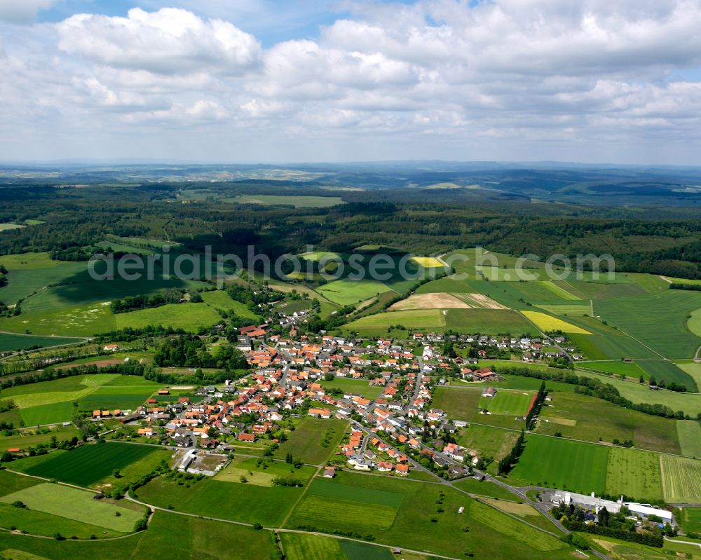 Stockhausen from the bird's eye view: Agricultural land and field boundaries surround the settlement area of the village in Stockhausen in the state Hesse, Germany