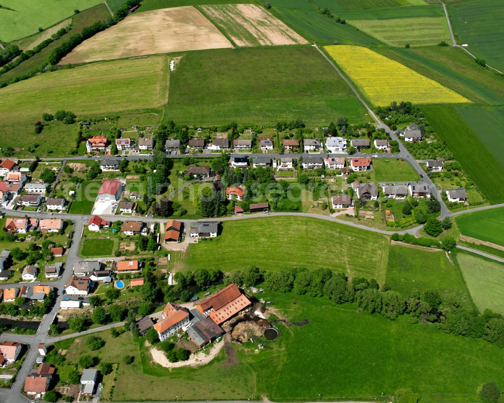 Stockhausen from above - Agricultural land and field boundaries surround the settlement area of the village in Stockhausen in the state Hesse, Germany