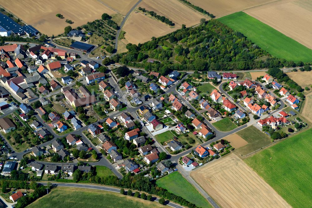 Sulzdorf from the bird's eye view: Agricultural land and field boundaries surround the settlement area of the village in Sulzdorf in the state Bavaria, Germany