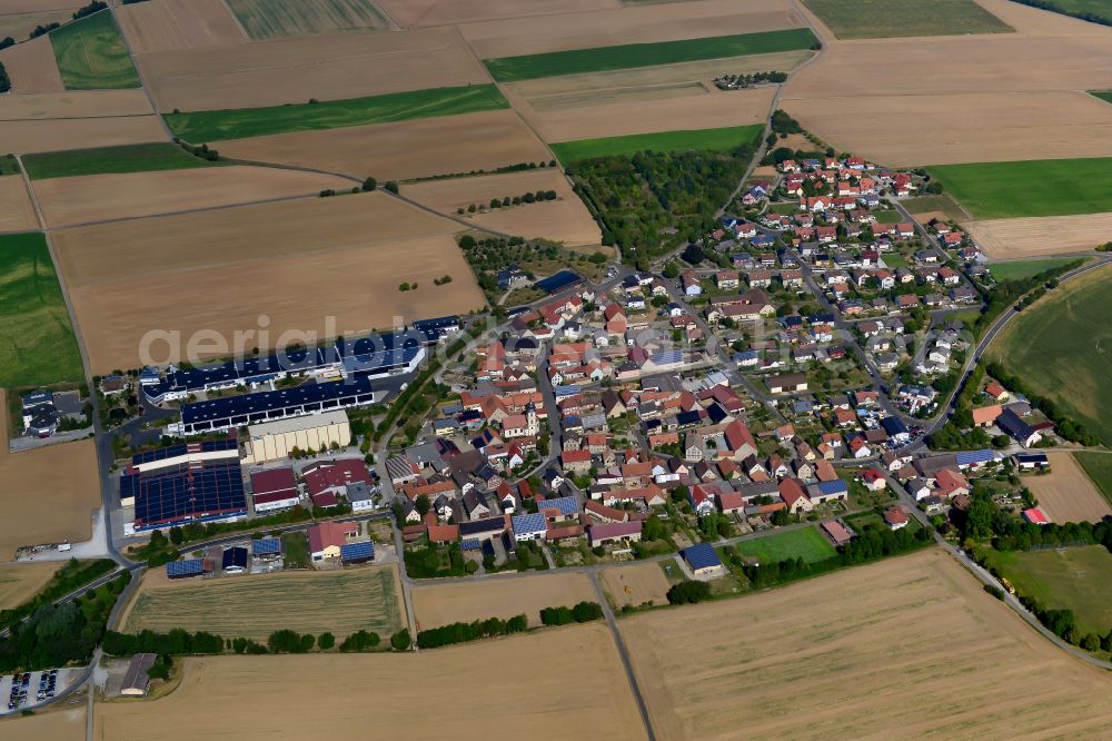 Sulzdorf from above - Agricultural land and field boundaries surround the settlement area of the village in Sulzdorf in the state Bavaria, Germany