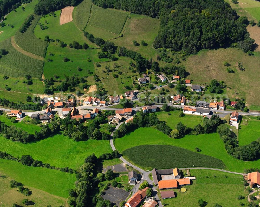 Aerial image Unter-Ostern - Agricultural land and field boundaries surround the settlement area of the village in Unter-Ostern in the state Hesse, Germany