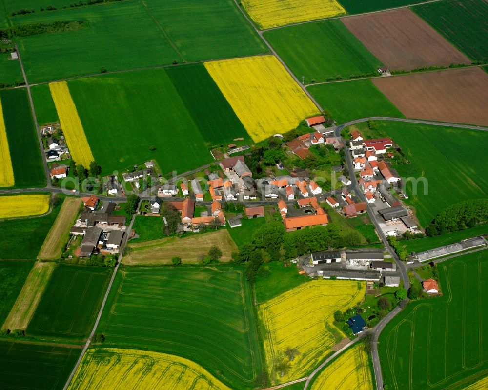 Unterweisenborn from the bird's eye view: Agricultural land and field boundaries surround the settlement area of the village in Unterweisenborn in the state Hesse, Germany